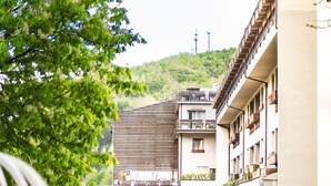 Un hotel con patio central, acceso cubierto y un paisaje de colinas al fondo.