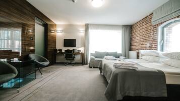 Une chambre d’hôtel moderne équipée d’un lit, d’un bureau, d’une chaise et d’un téléviseur.