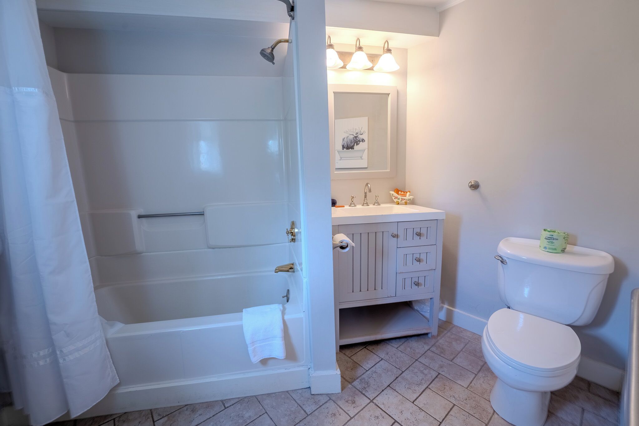 A bathroom with a bathtub, toilet, and vanity.
