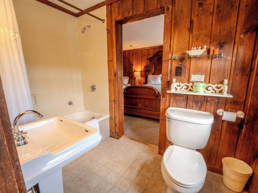 A bathroom with a sink, toilet, and wooden walls.