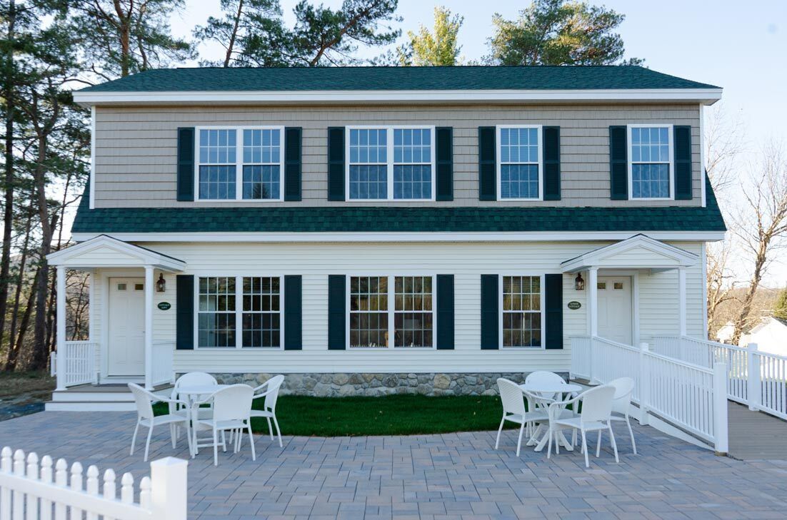 A two-story house with a covered patio area.