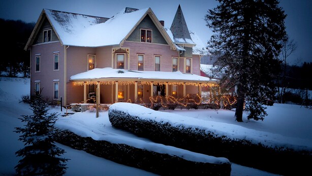 A large, multi-story house with a snow-covered roof and a prominent tower. - Margaretville Mtn Inn B&B and Village Suites (Margaretville)