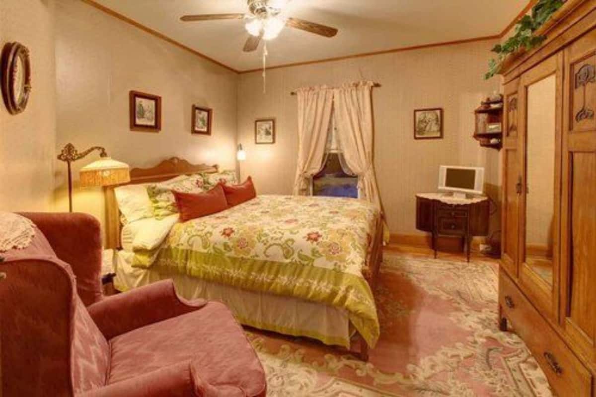 Une chambre à coucher comprenant un lit, une chaise, un bureau et une armoire.