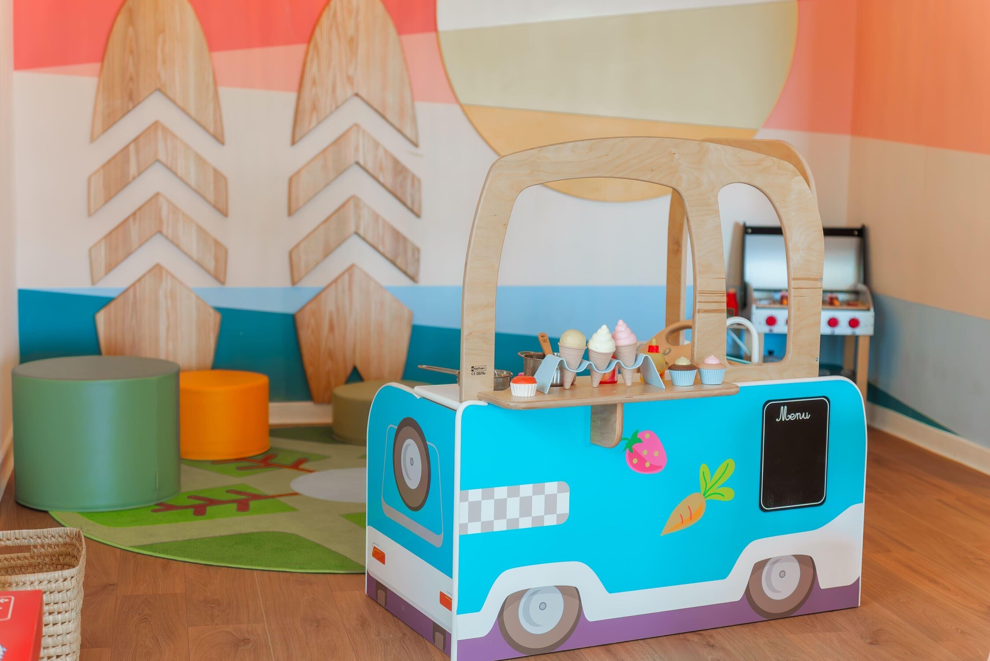 A toy food truck with a handle, wheels, and a menu sign.
