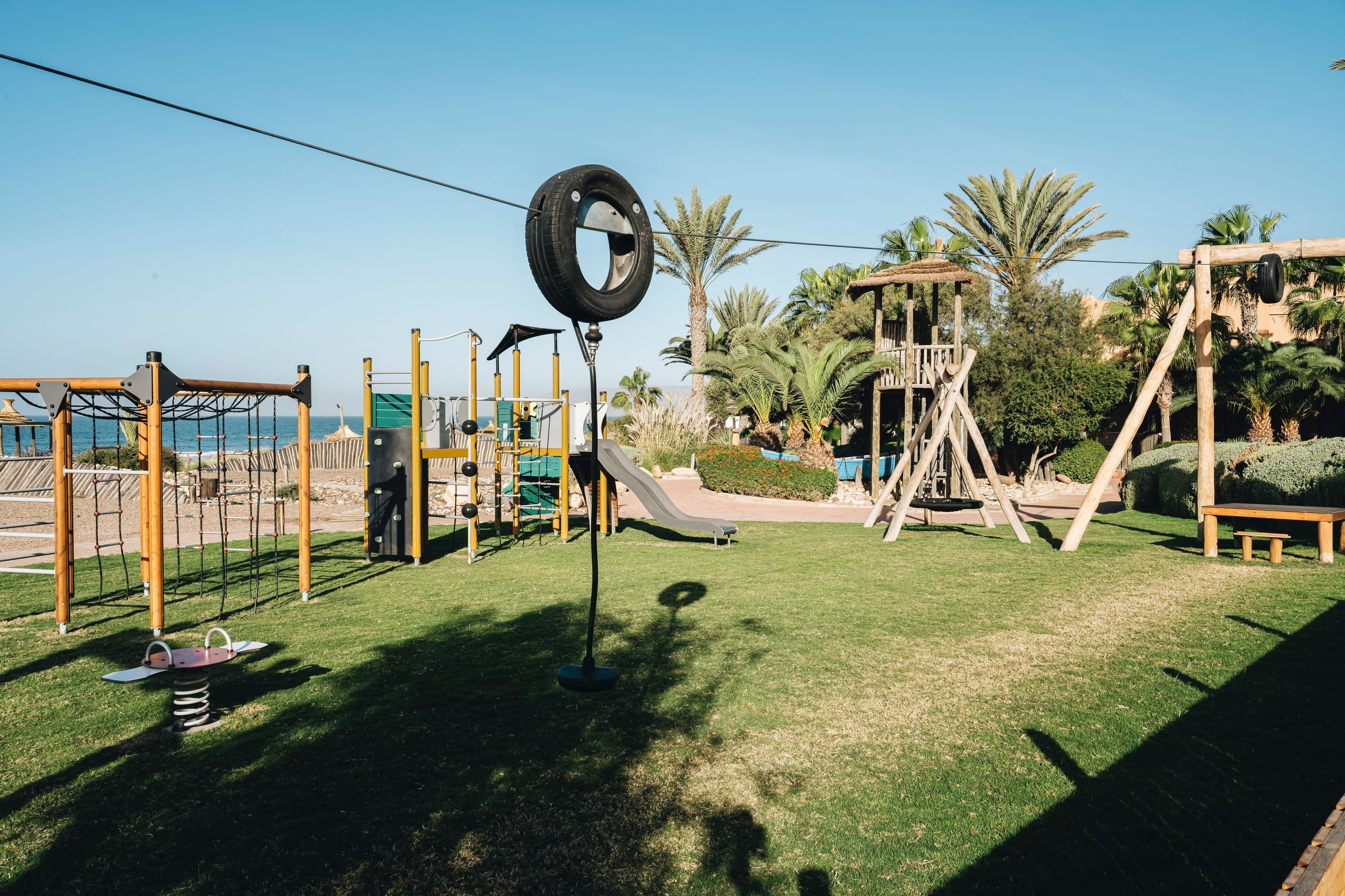 A playground with various play equipment including swings, slides, and climbing structures.