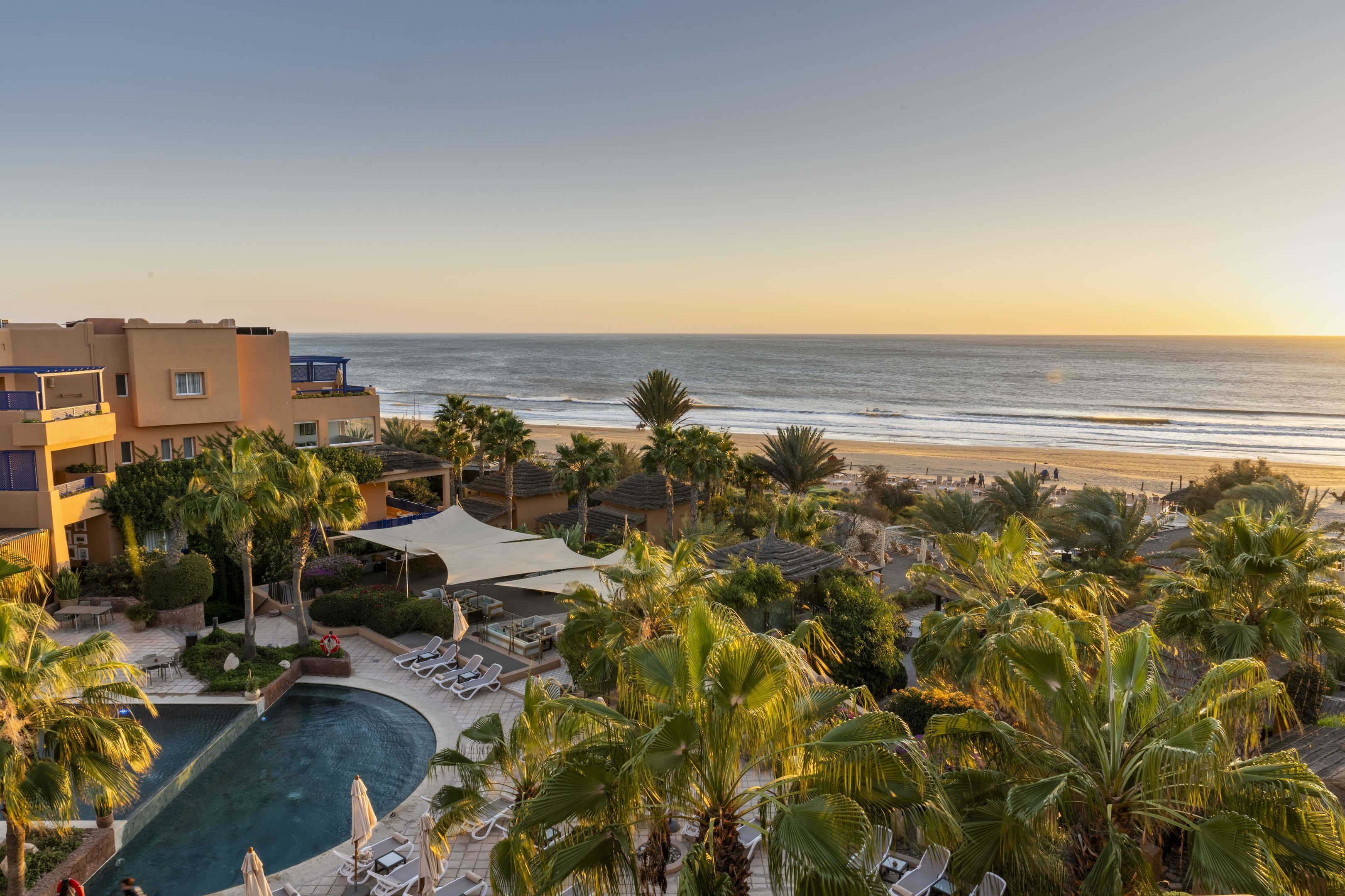 Una piscina al aire libre, sombrillas, tumbonas