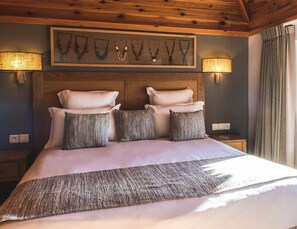 A bed with a wooden headboard, multiple pillows, and a decorative wall piece above.