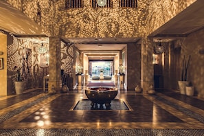 A spacious lobby with a central water feature, patterned walls, and a view to the outside. - Paradis Plage Surf Yoga & Spa resort (Tamri)