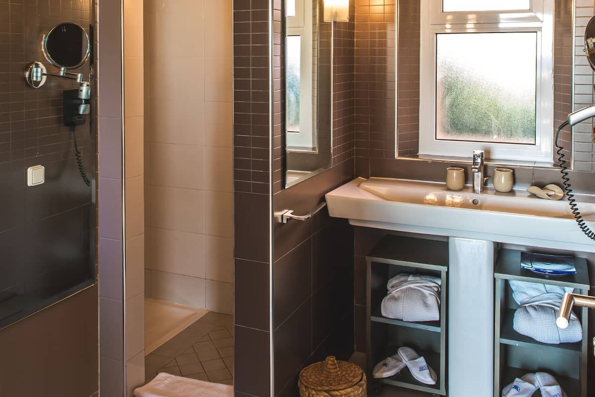 Shower, designer toiletries, hair dryer, slippers