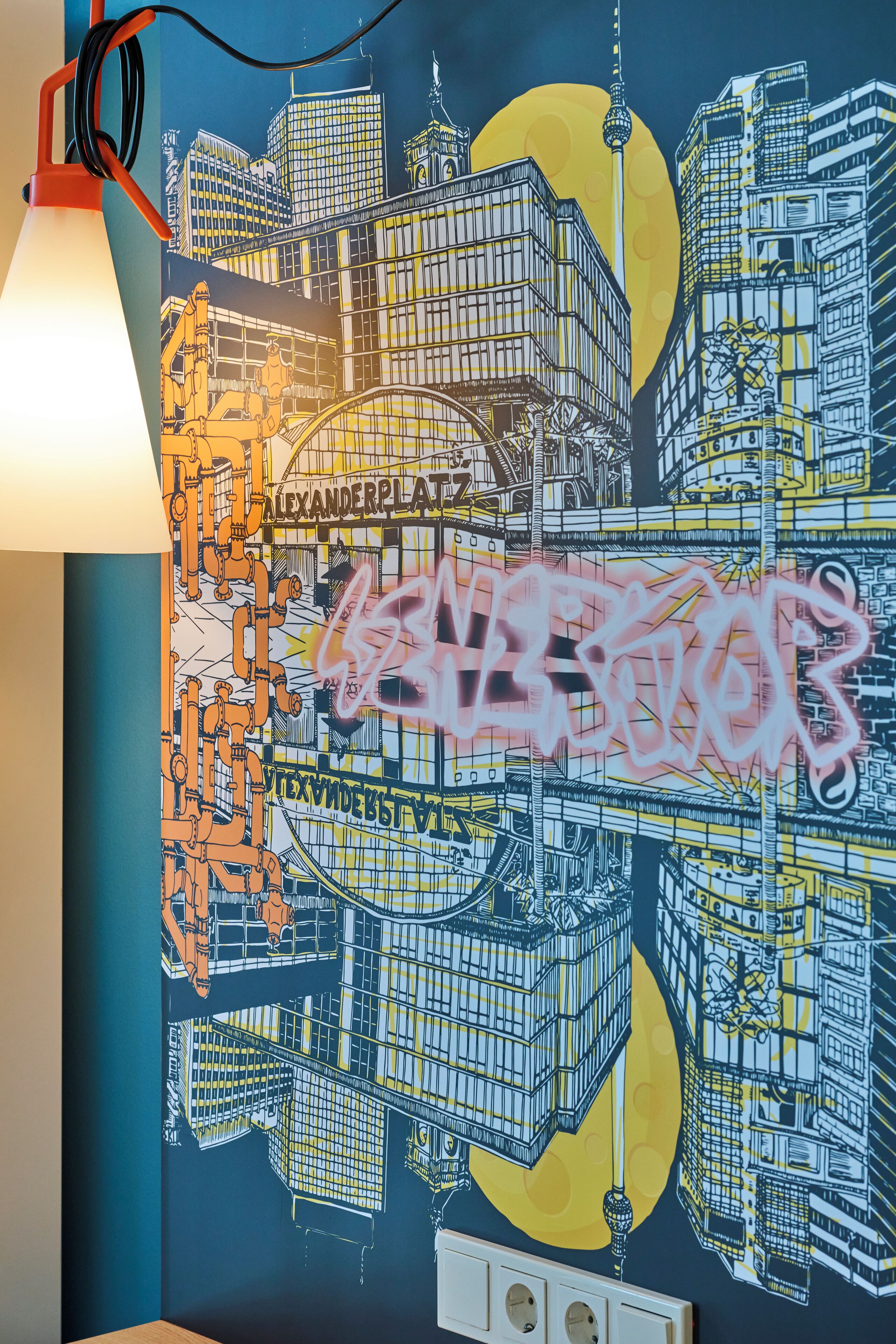 Ein Wandgemälde mit Stadtansicht und dem Schriftzug "ALEXANDERPLATZ" und "GENDERS".