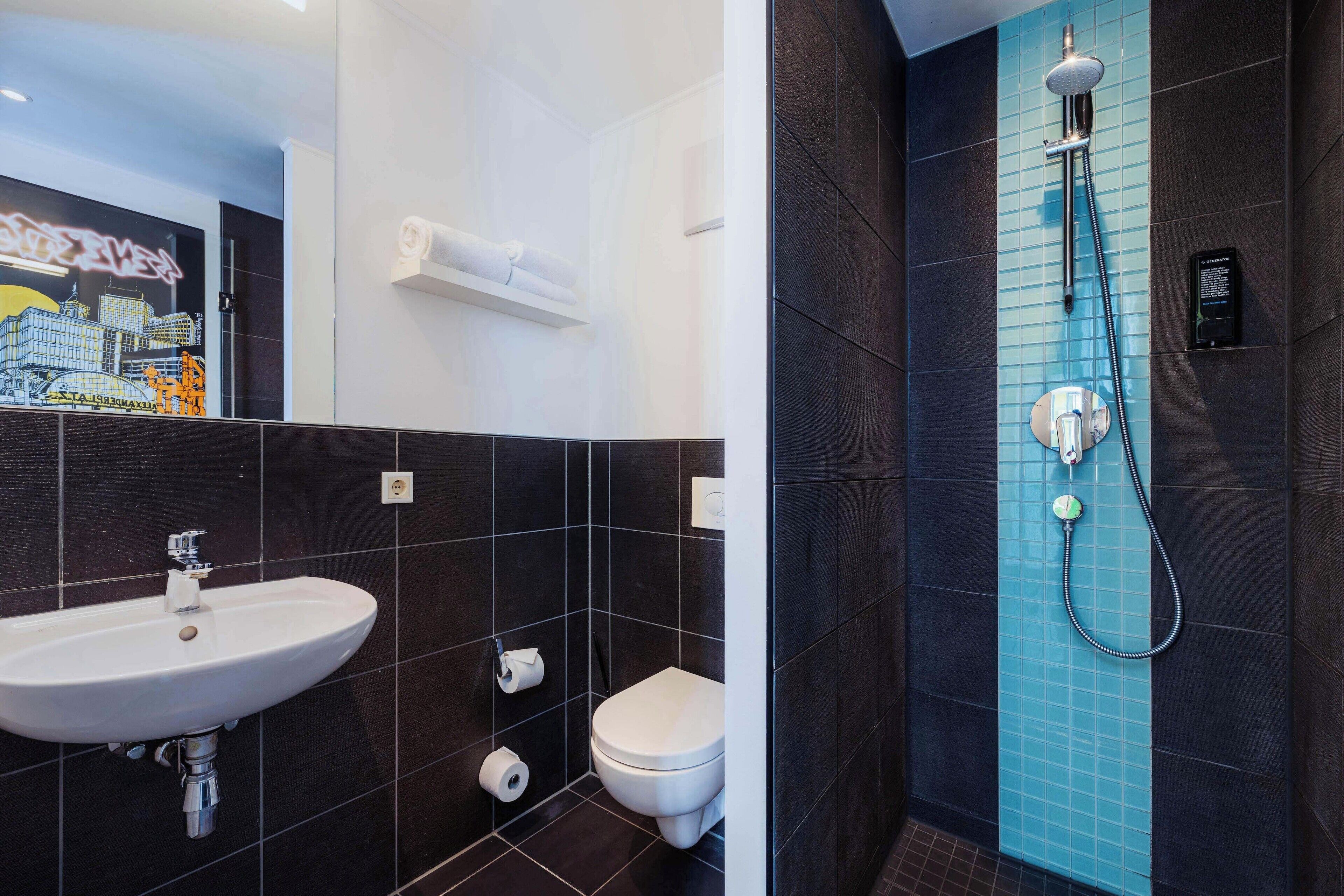 A modern bathroom with a white sink, toilet, and shower.