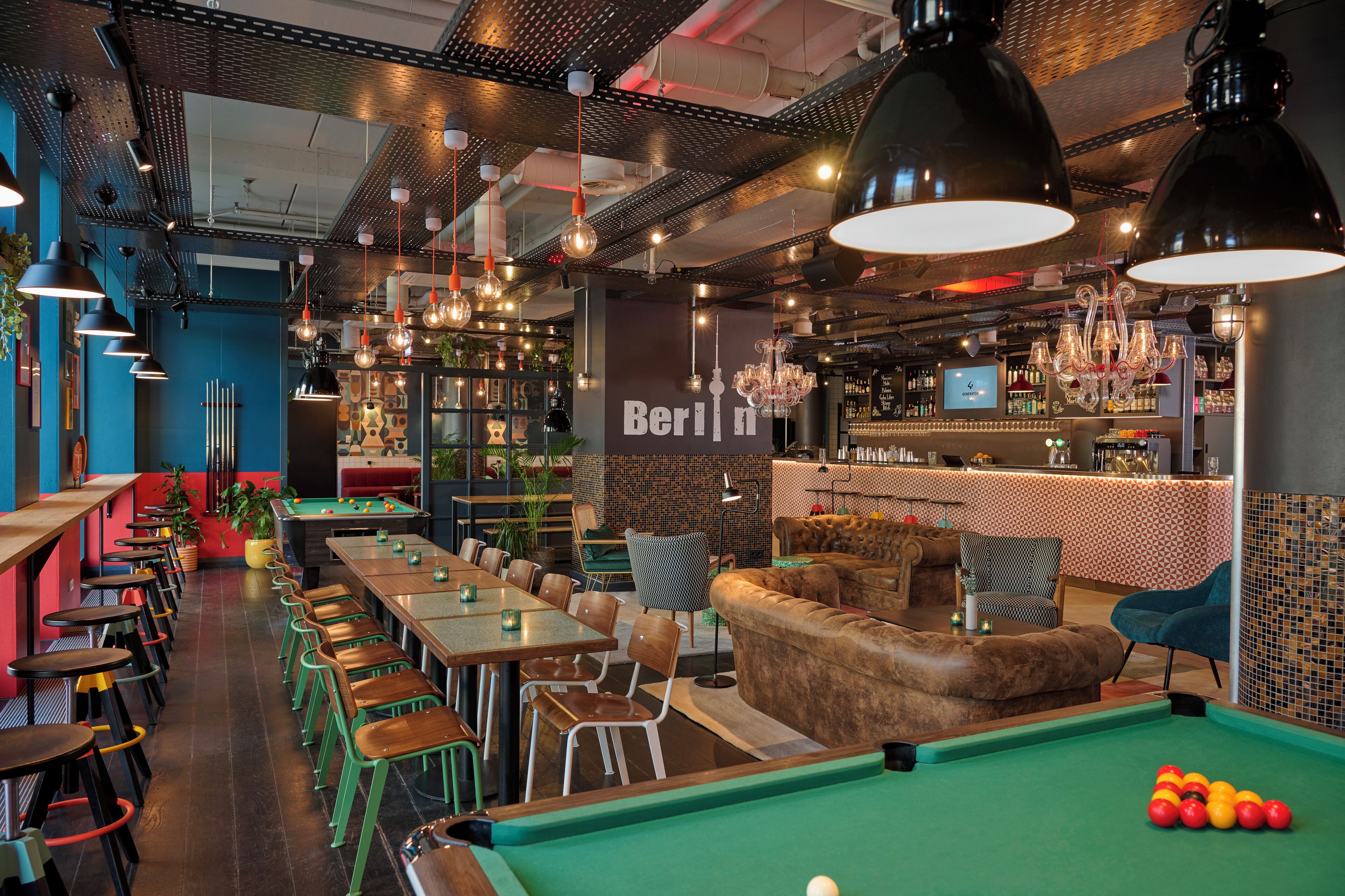 Ein Billardtisch mit Kugeln, eine Bar mit Theke und Flaschenregalen.
