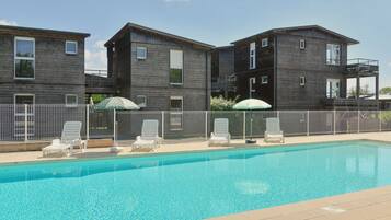 Een seizoensgebonden buitenzwembad en parasols bij het zwembad