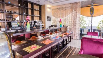 Eine moderne Hotelhalle mit langer Rezeption, Bar und Sitzgelegenheiten.