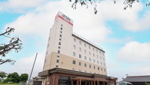 Un hôtel à plusieurs étages, reconnaissable à son grand panneau indiquant « TSUKUBA SKY HOTEL ».