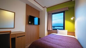 A hotel room with a bed, a desk, a television, and a window with a view. - Mito Hotel Season (Mito)