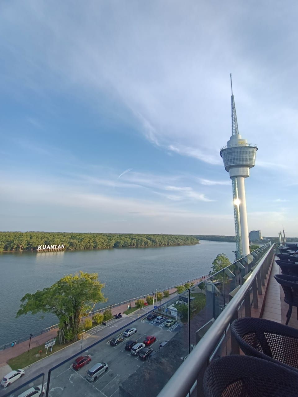 Ein Hochhaus mit einer Aussichtsplattform, das auf ein Gewässer und eine Stadtansicht blickt.