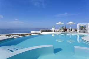 Una piscina al aire libre de temporada, sombrillas, tumbonas