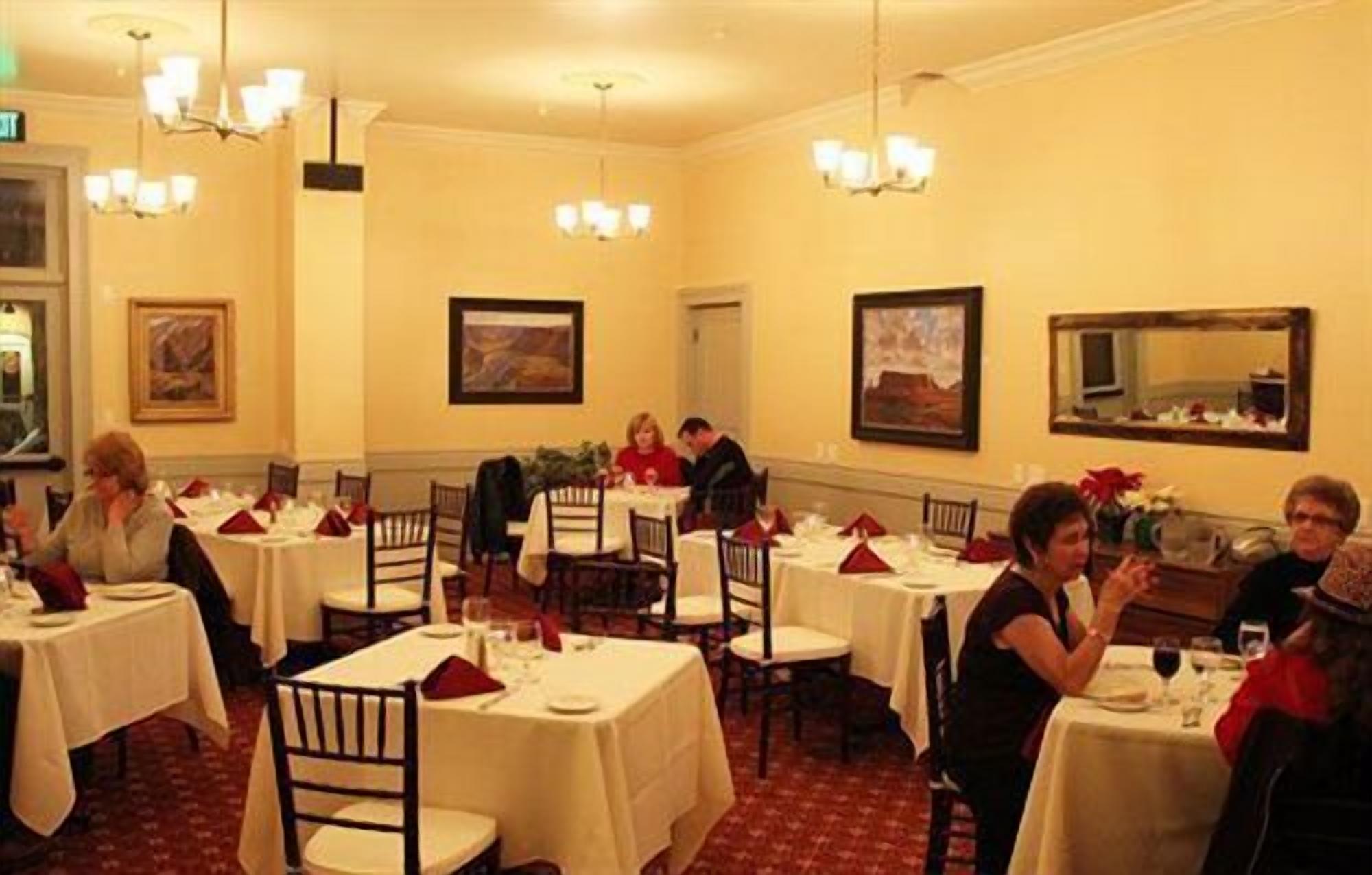 Un espace repas comprenant plusieurs tables, des chaises et des lustres.