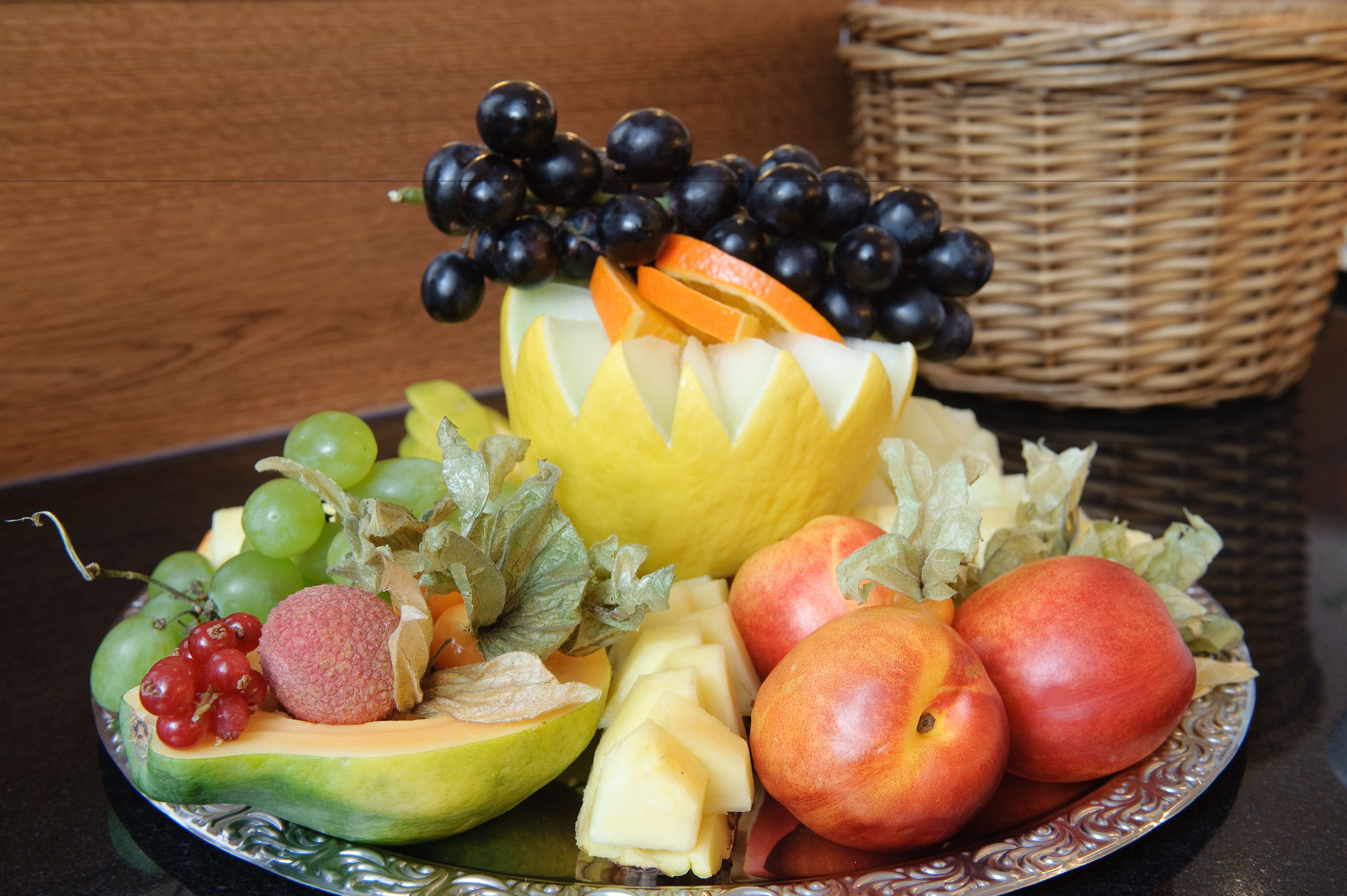 A fruit platter with various fruits and a decorative centerpiece.