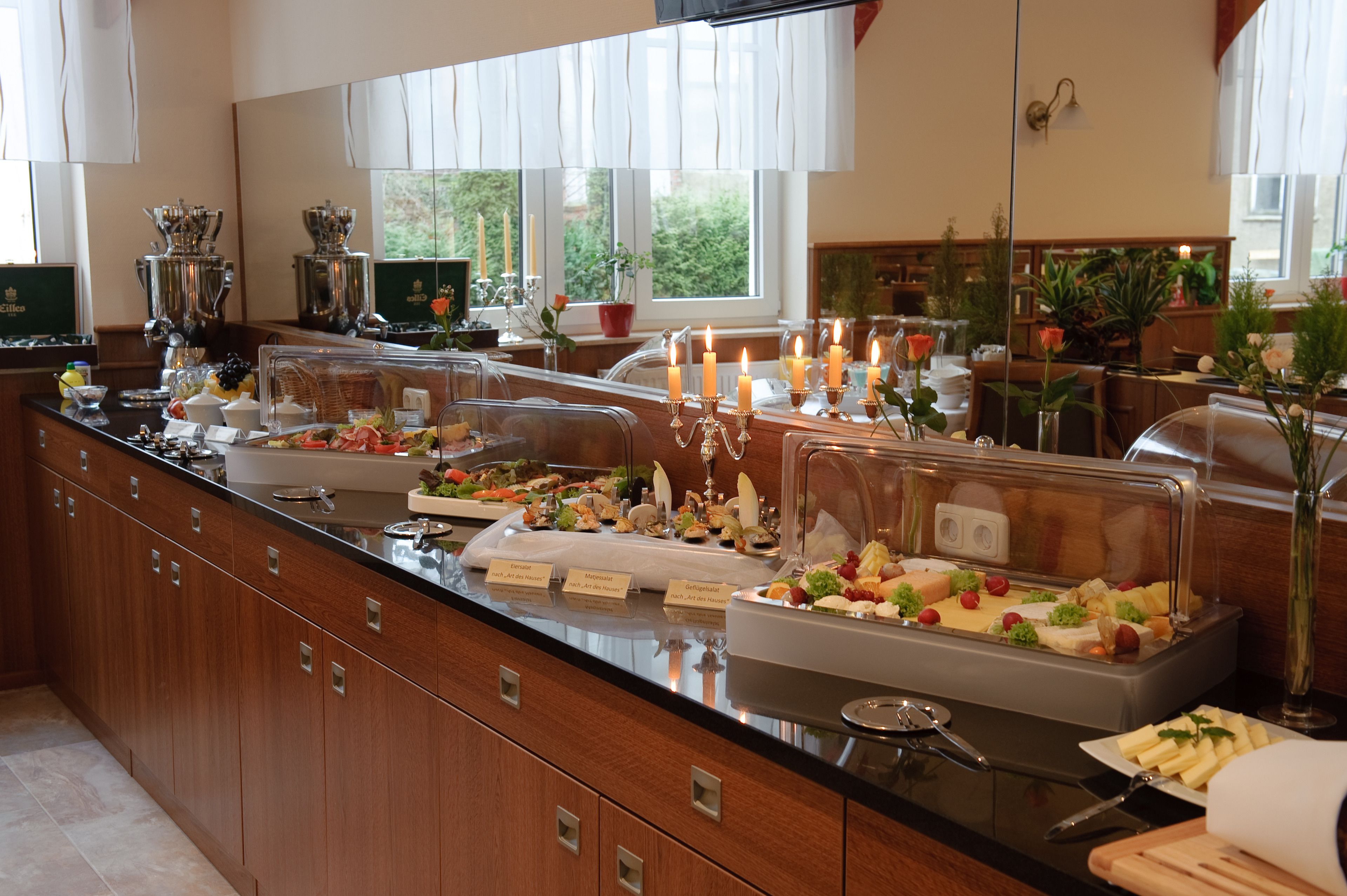 A buffet setup with various food items and a coffee station.