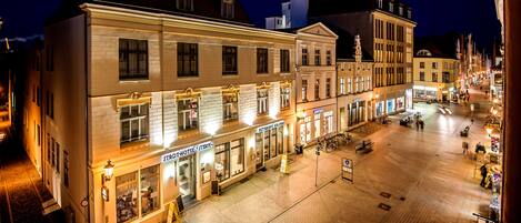 Ein Hotel mit Restaurant im Erdgeschoss und einer zweiten Etage mit großen Fenstern.