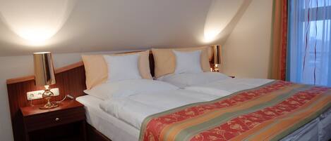 Une chambre d’hôtel avec un lit, des tables de chevet et une lampe.