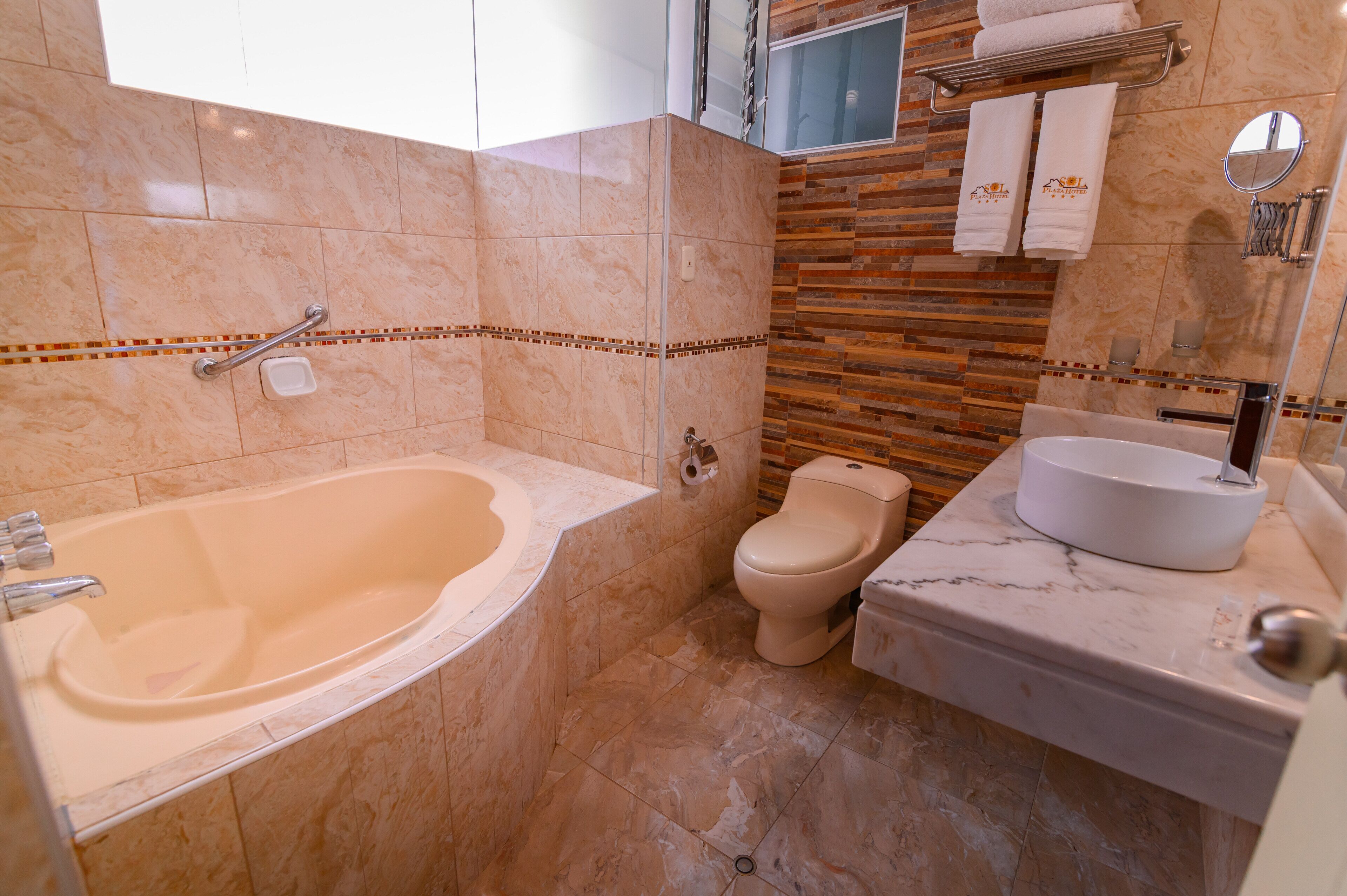A bathroom with a bathtub, toilet, and sink.