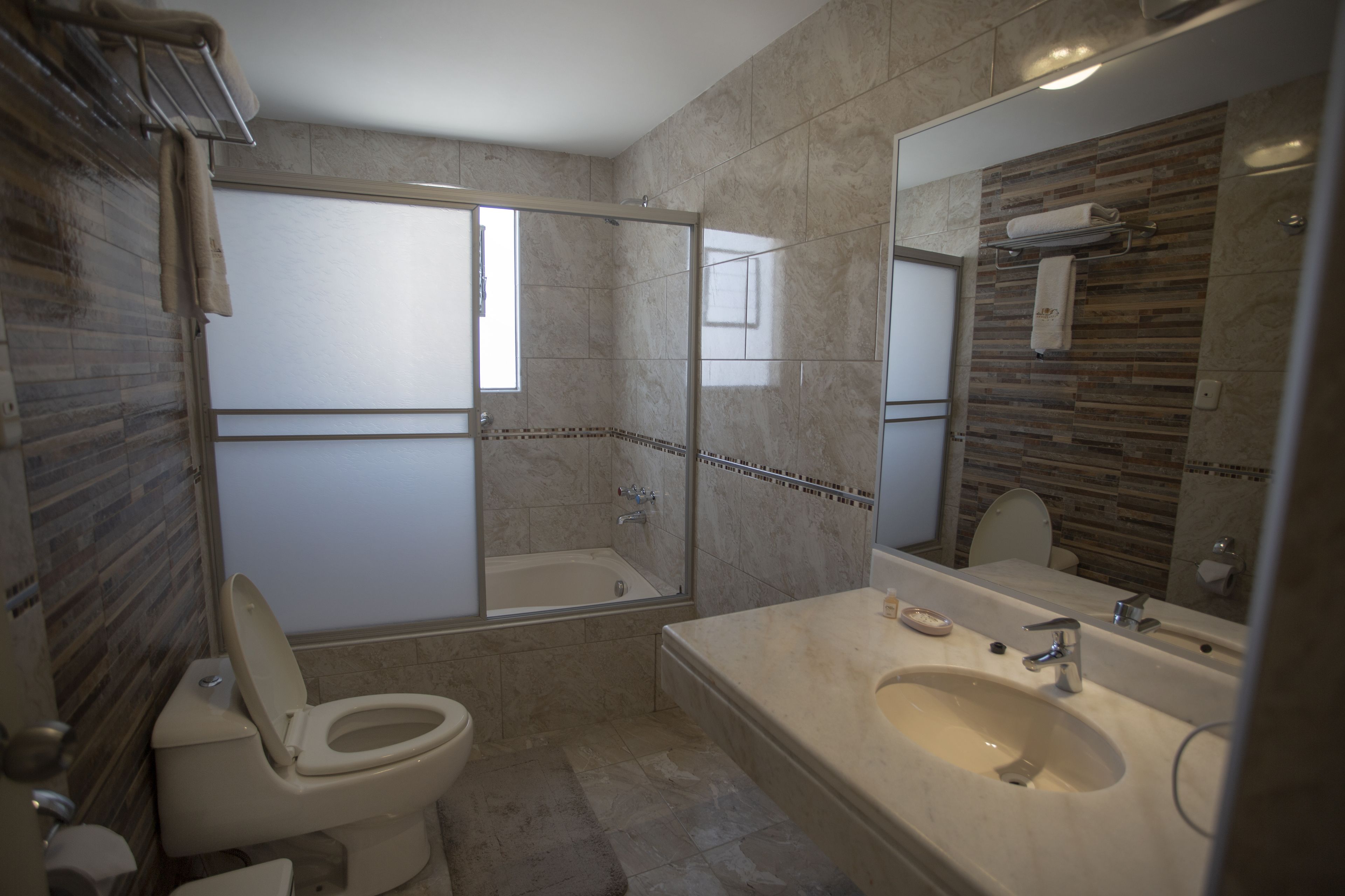 Une salle de bain comprenant des toilettes, une baignoire, une douche et un lavabo.