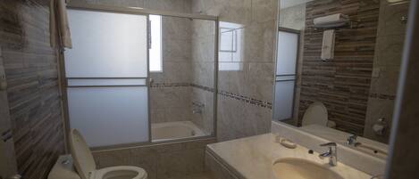 Une salle de bain comprenant des toilettes, une baignoire, une douche et un lavabo.