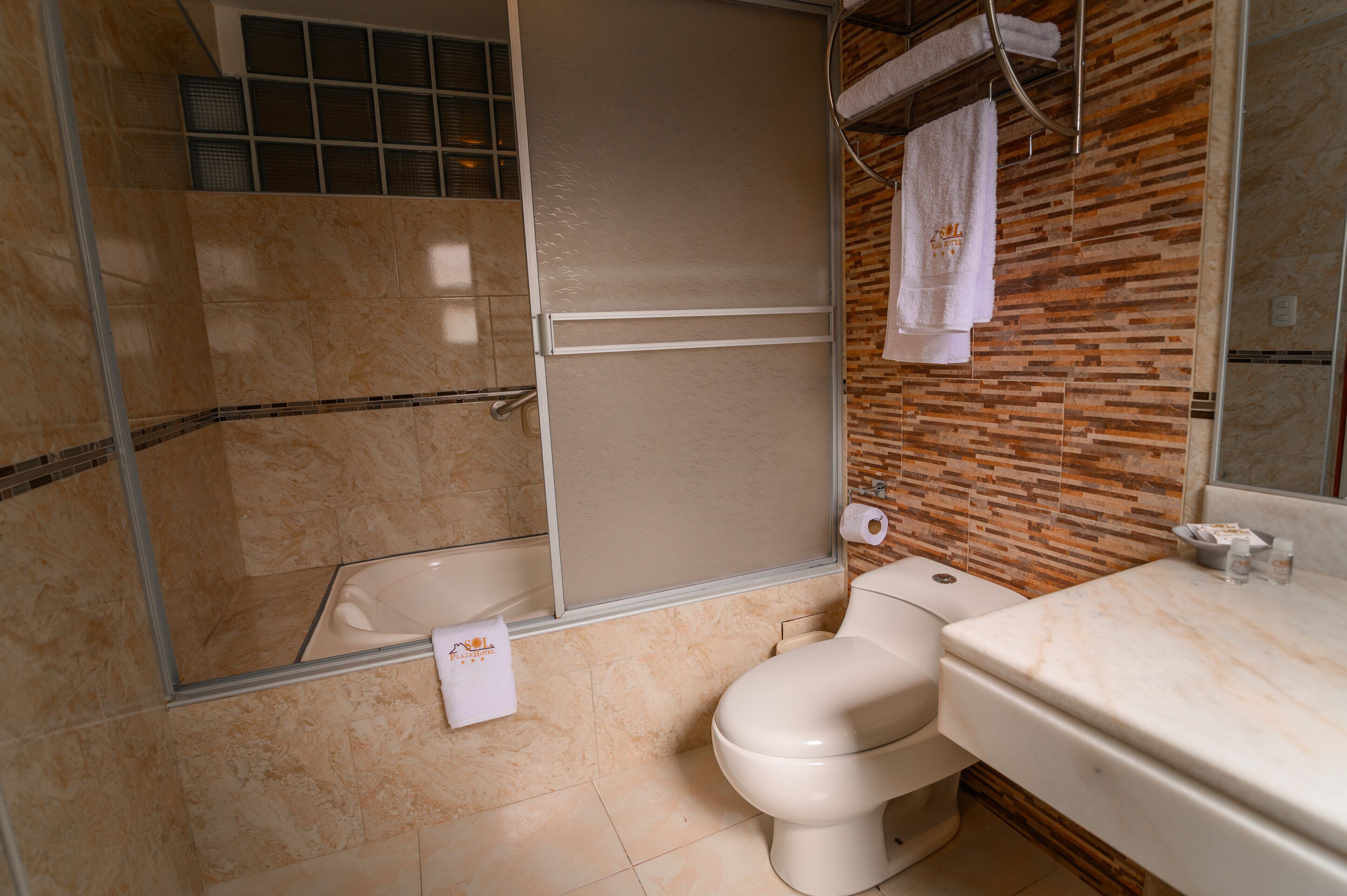 A bathroom with a shower, toilet, and sink.