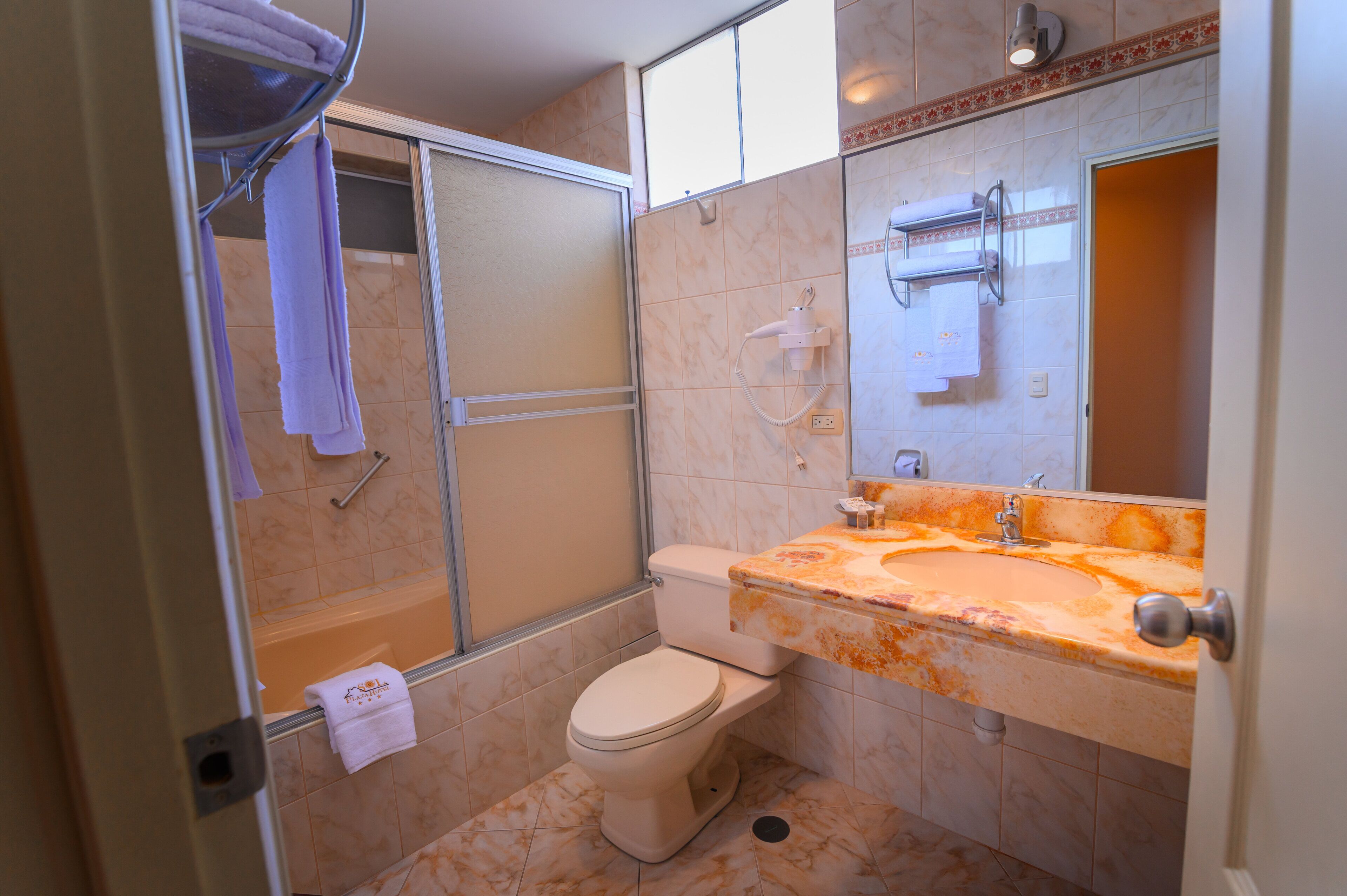 A bathroom with a shower, toilet, and sink.