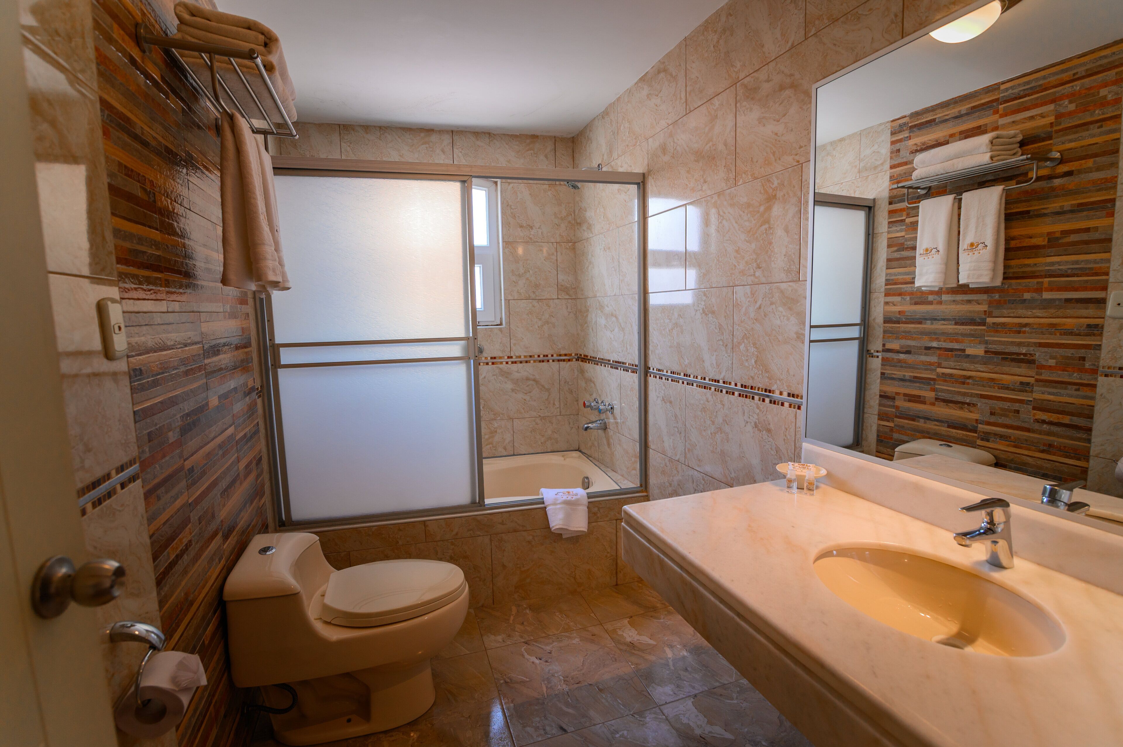 A bathroom with a shower, toilet, and sink.