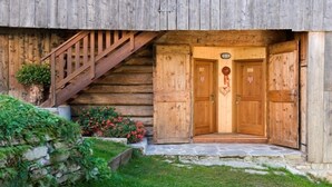 A wooden cabin with a wooden staircase leading to a door with a coat of arms. - Albergo Diffuso Sauris In Sauris di Sopra (Sauris)
