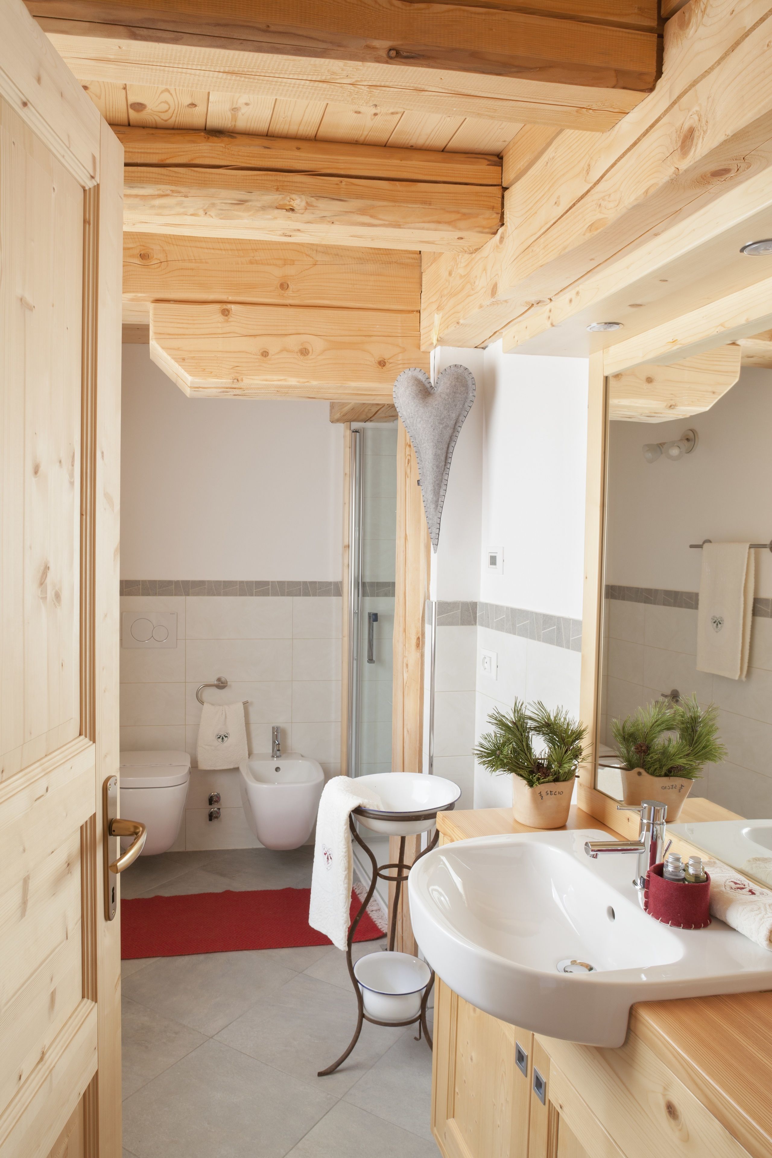 Baño de cabaña de madera con lavamanos, inodoro y ducha.