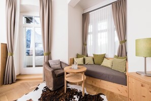 A cozy room with a sofa, a small round table, and a lamp.