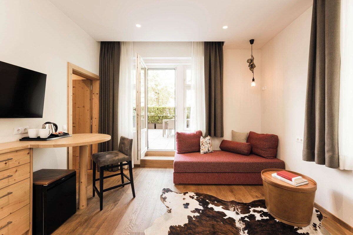 A modern living room with a sofa, a coffee table, a TV, and a dining area with a table and chairs.