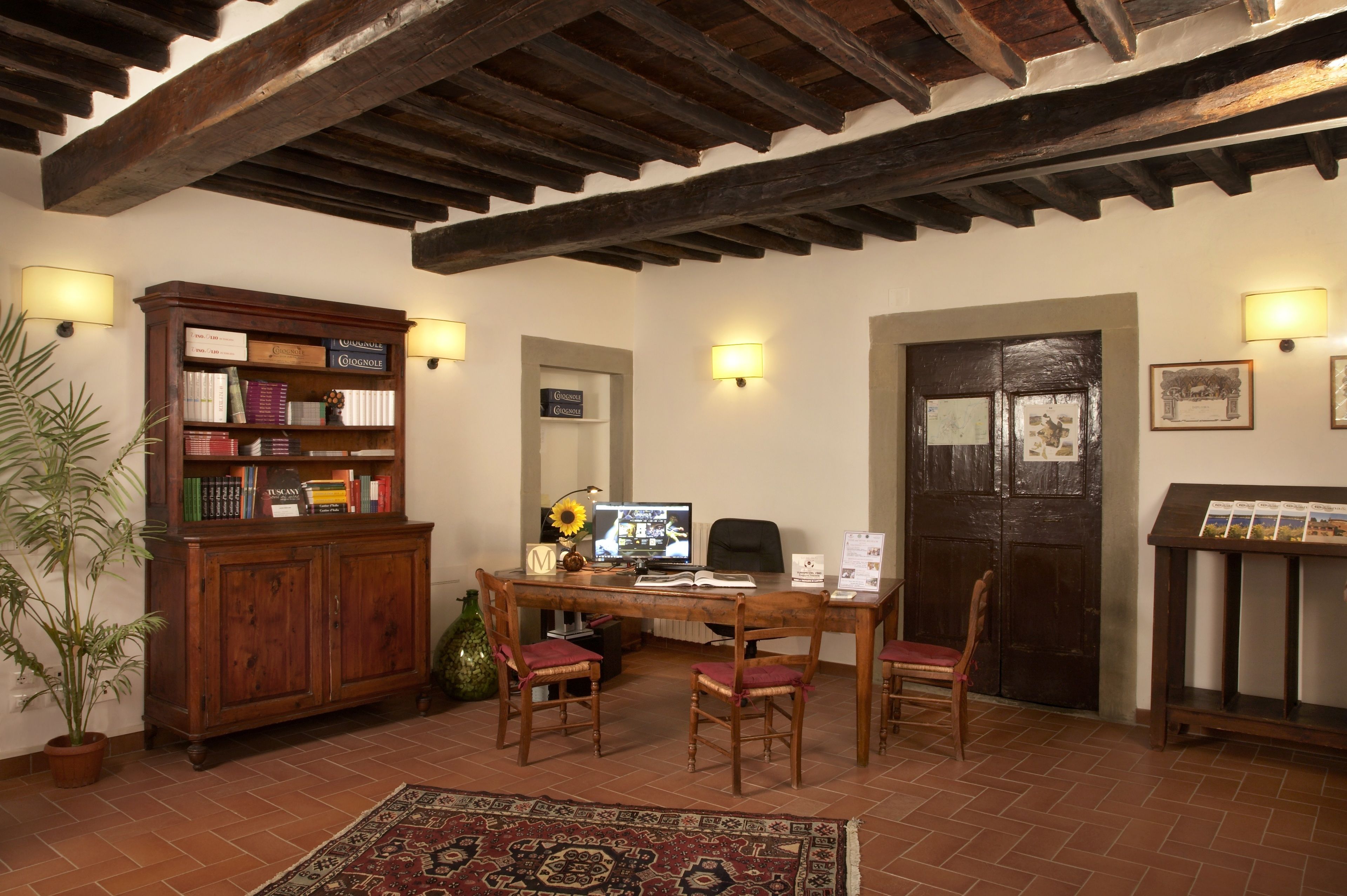 A cozy room with a wooden desk, bookshelves, and a large window.