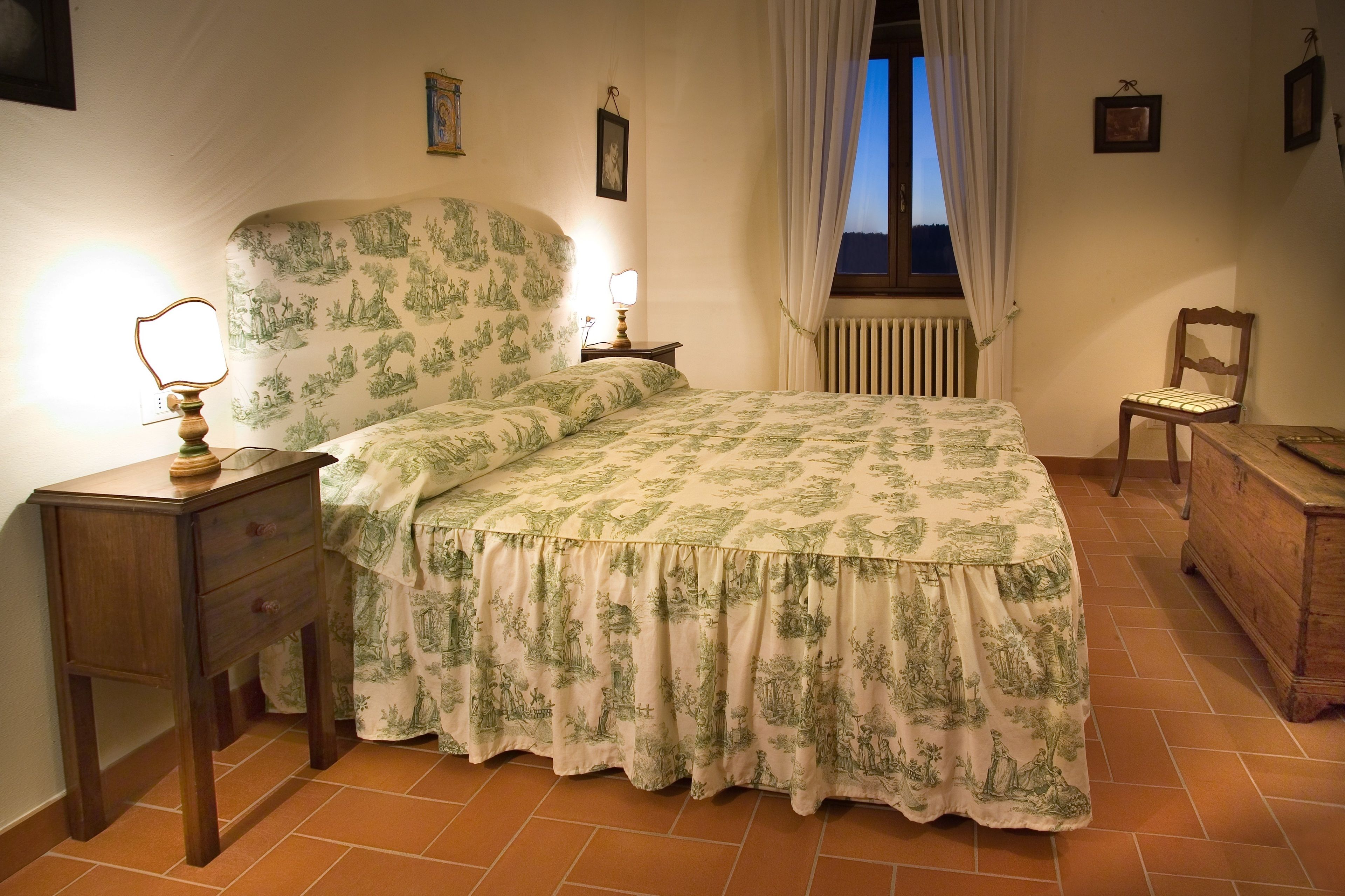 A bedroom with a bed, a nightstand, a chair, and a dresser.