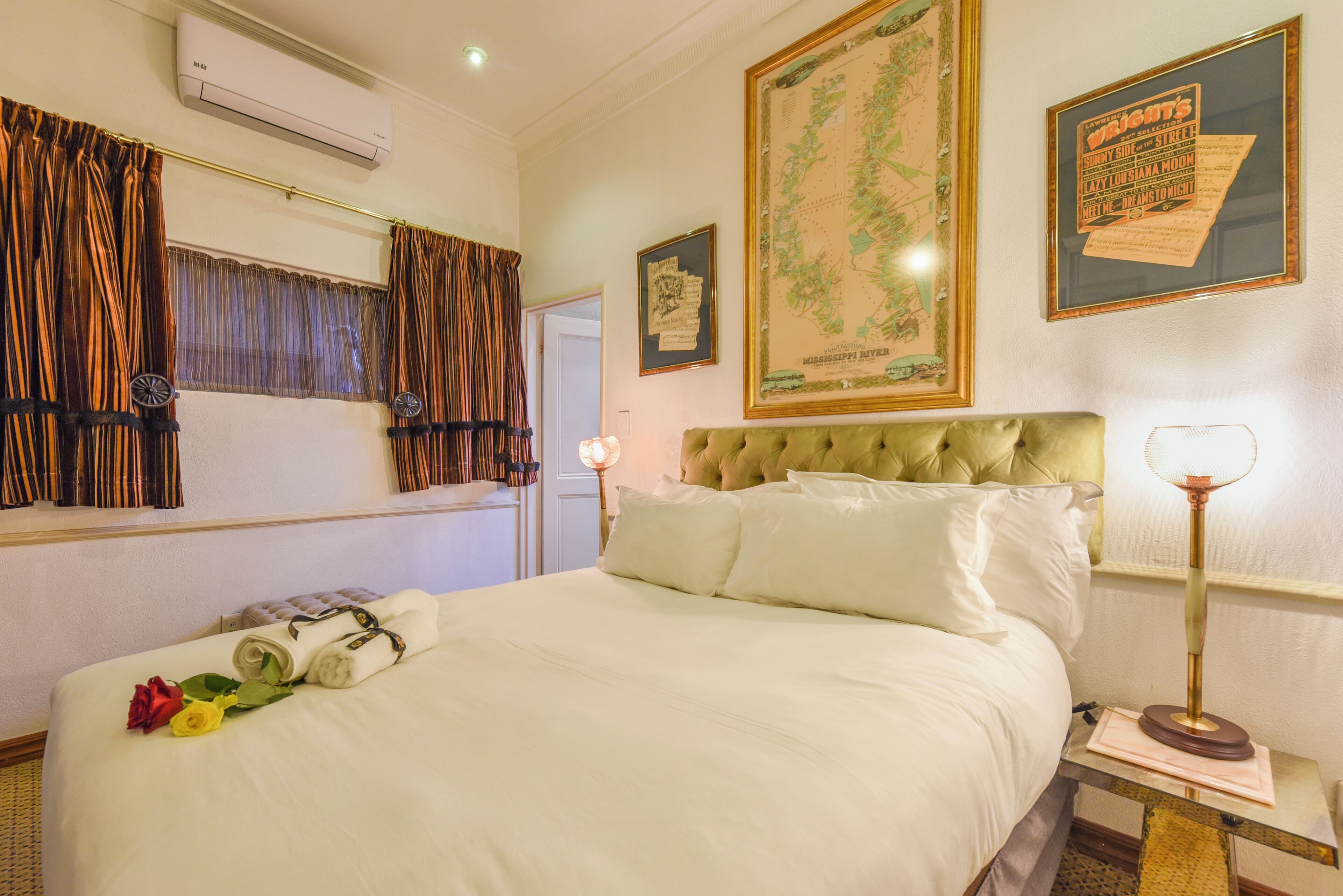 A hotel room with a large bed, a map on the wall, and a framed menu on the wall.