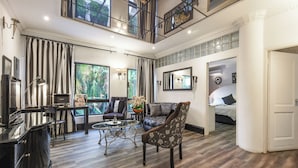 A spacious living area with a high ceiling, a balcony, a dining area, and a bedroom. - Villa Simonne (Johannesburg)