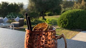 Un vaso de cobre con asa sobre una mesa al aire libre.