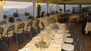 Ein Restaurant mit gedeckten Tischen, Stühlen und Blick auf die Berge.