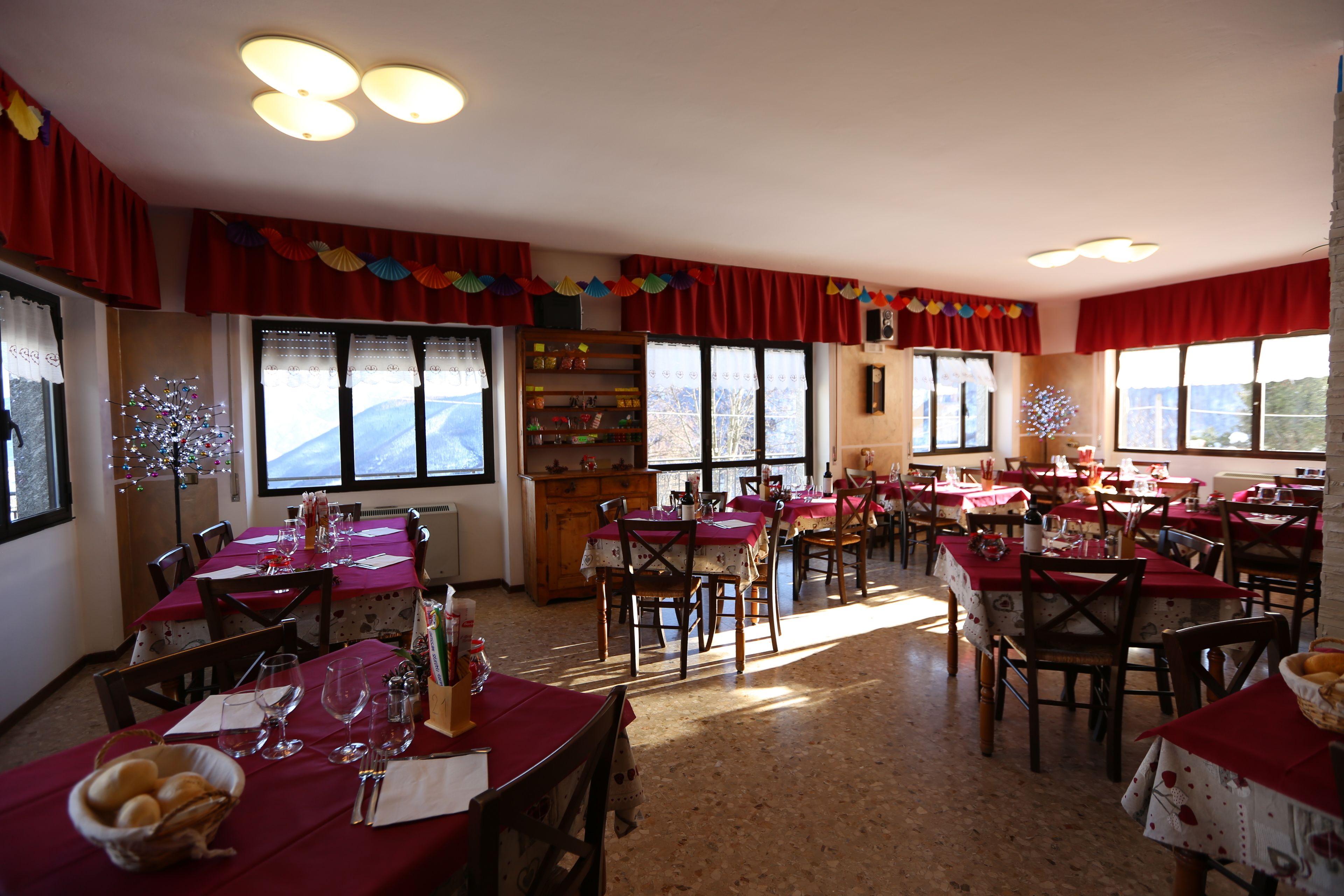 A dining area with multiple tables, chairs, and a buffet setup.