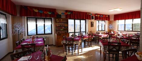 A dining area with multiple tables, chairs, and a buffet setup.