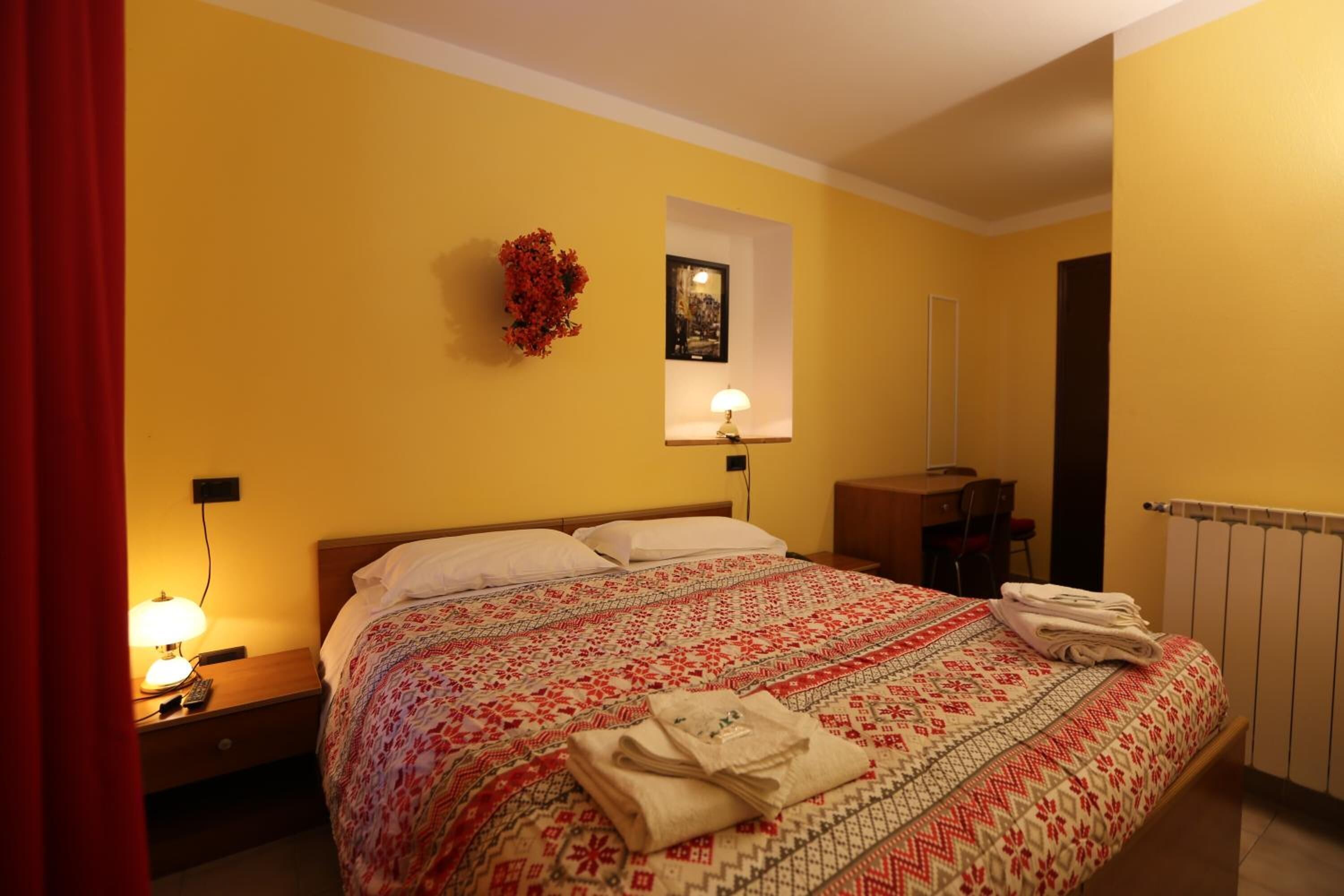Una habitación de hotel con cama, escritorio y silla.