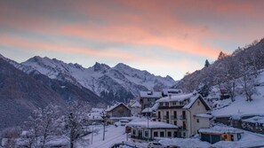 A snow-covered mountain village with traditional buildings and a view of the mountains. - Albergo Da Cecilia (Bognanco)