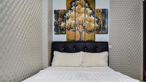 Un dormitorio con una cama, cabecera y pared con diseño geométrico.