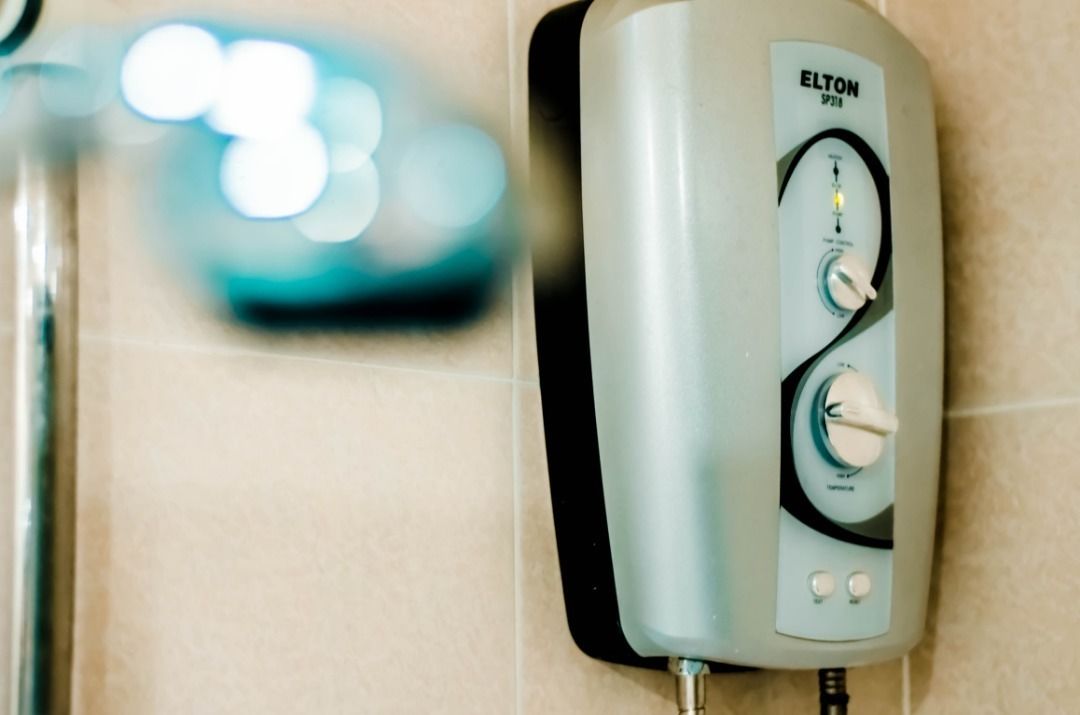 Um aquecedor de água fixado na parede, com manípulos de controle e o nome da marca.