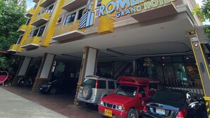 Ein mehrstöckiges Hotel mit Balkonen und einem gut sichtbaren Schild mit der Aufschrift 'ROMENA GRAND HOTEL'.